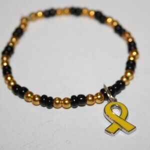 Gold and black glass beaded bracelet with yellow awareness ribbon charm